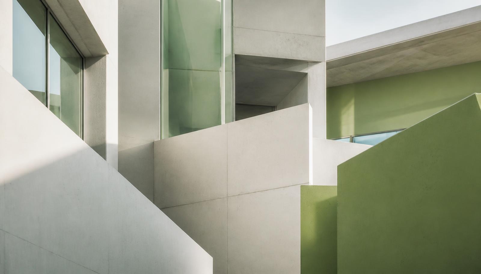 Sonnenbeschienene moderne Architektur aus Beton und grünen Flächen